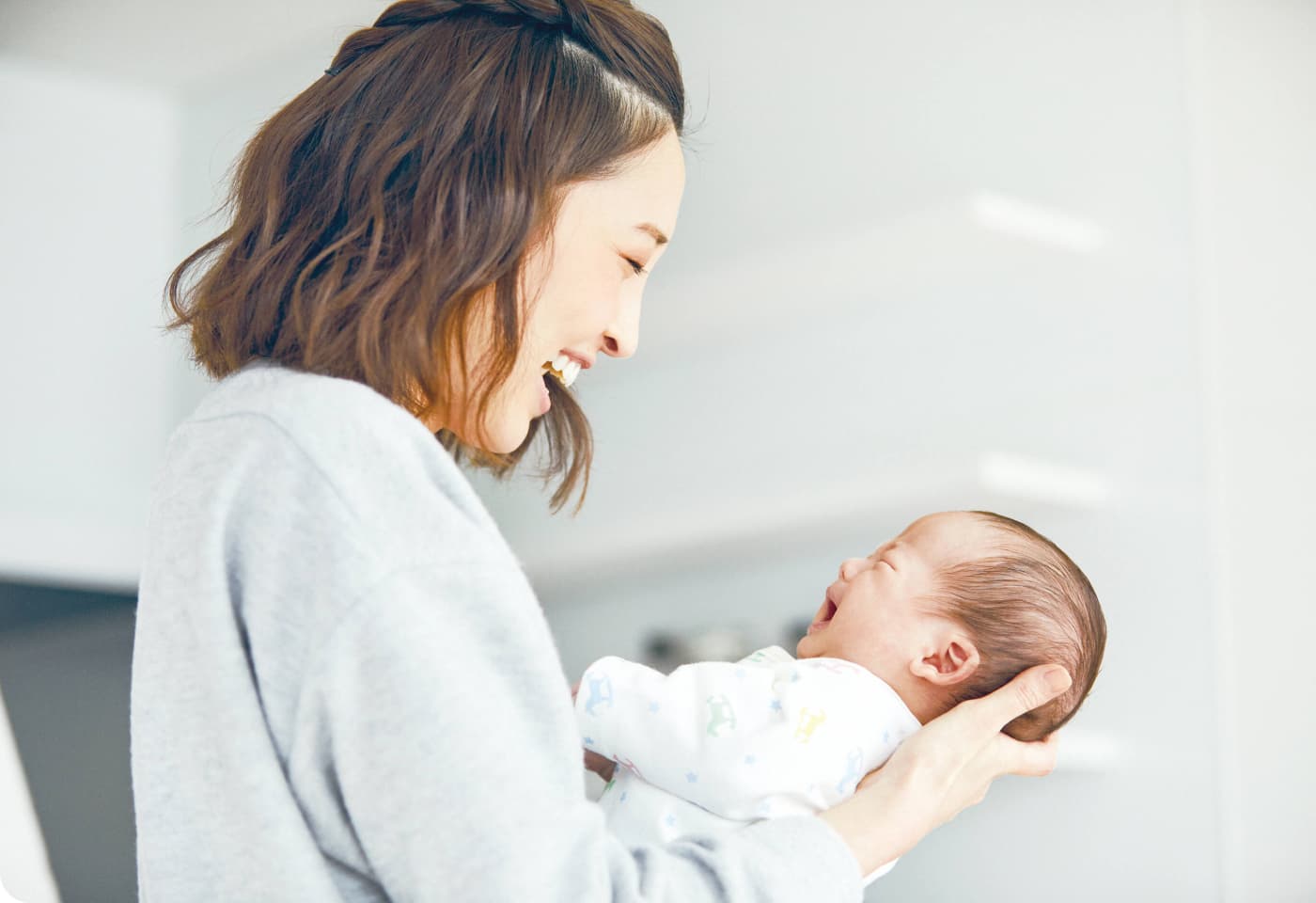 赤ちゃんを抱き微笑むお母さん