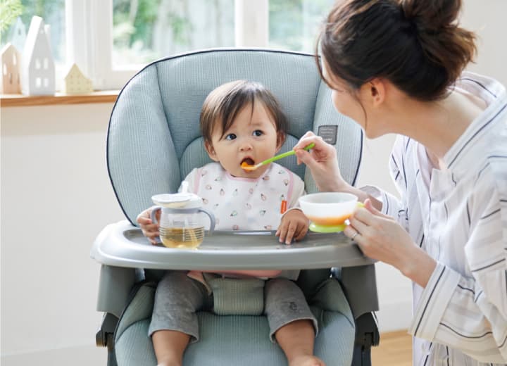 赤ちゃんに離乳食を与えるお母さん